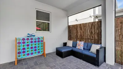 a patio with a blue couch and a table at Rent the Perfect 8 Bedroom Villa on Storey Lake Resort Orlando Villa 6293 in Kissimmee