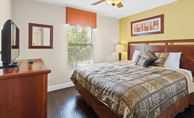 a bedroom with a bed and a desk and a television at Beautiful House with first class amenities on Paradise Palms Resort Orlando House 6298 in Kissimmee