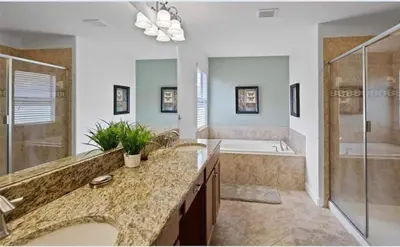 a bathroom with two sinks and a shower and a tub at Beautiful House with first class amenities on Paradise Palms Resort Orlando House 6298 in Kissimmee