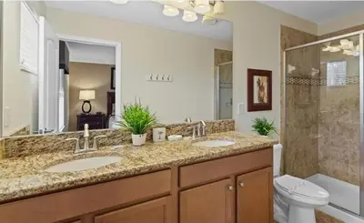 a bathroom with two sinks and a toilet at Beautiful House with first class amenities on Paradise Palms Resort Orlando House 6298 in Kissimmee