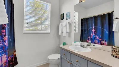a bathroom with a sink and a toilet and a window at Orlando Condo 6420: Family-Friendly Resort Near Disney in Kissimmee