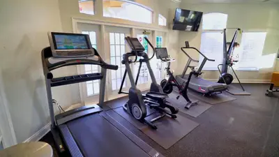 a gym with exercise bikes and a laptop on a treadmill at Luxury Orlando Townhome 6425 - Emerald Island Resort Stay in Kissimmee