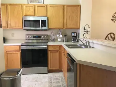 a kitchen with a stove and a sink and a microwave at Luxury Orlando Townhome 6425 - Emerald Island Resort Stay in Kissimmee