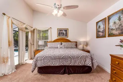 a bedroom with a bed and a ceiling fan at Orlando Villa 6426: Cumbrian Lakes Pool Spa Retreat in Kissimmee