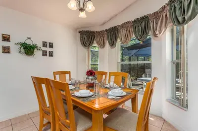 a dining room with a wooden table and chairs at Orlando Villa 6426: Cumbrian Lakes Pool Spa Retreat in Kissimmee