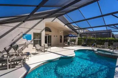 a swimming pool with chairs and a large glass ceiling at Orlando Villa 6426: Cumbrian Lakes Pool Spa Retreat in Kissimmee