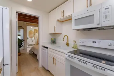 a kitchen with white cabinets and a sink at Orlando Home 6430: Purpose-Driven A-Frame Vacation Home in Clermont