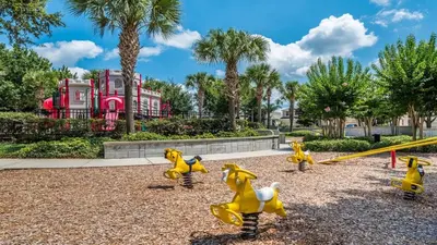 a playground with yellow toy dogs and a swing at Orlando Townhome 6436: Family Fun Near Disney World in Orlando