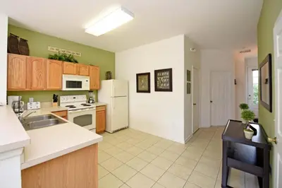 a kitchen with white appliances and green walls at Orlando Townhome 6436: Family Fun Near Disney World in Orlando