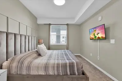 a bedroom with a bed and a tv on the wall at Book Now: Orlando Condo 6439 at Storey Lake Resort in Kissimmee