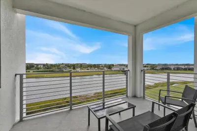 a balcony with chairs and a view of the water at Book Now: Orlando Condo 6439 at Storey Lake Resort in Kissimmee