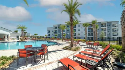 a patio with a table and chairs next to a pool at Book Now: Orlando Condo 6439 at Storey Lake Resort in Kissimmee