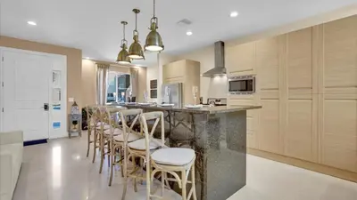 a kitchen with a bar with chairs and a counter at Book Now: Orlando Townhome 6440 Near Disney Magic in Orlando