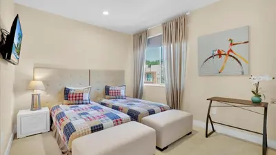 a bedroom with two beds and a window with a bicycle on the wall at Book Now: Orlando Townhome 6440 Near Disney Magic in Orlando