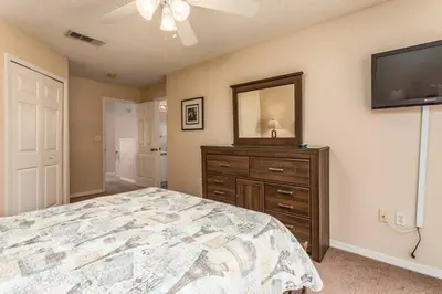 a bedroom with a bed and a dresser with a mirror at Stay Near Disney at Orlando Townhome 6444 Sleeps 8 in Kissimmee