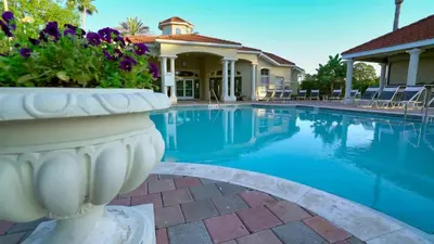 a villa with a swimming pool and a house at Stay Near Disney at Orlando Townhome 6444 Sleeps 8 in Kissimmee