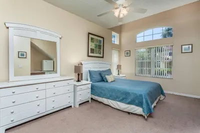 a bedroom with a bed and a dresser and a mirror at Stay Near Disney at Orlando Townhome 6444 Sleeps 8 in Kissimmee