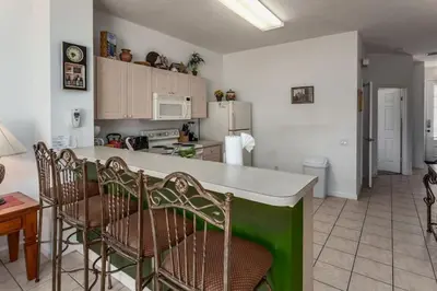 a kitchen with a counter and chairs in a room at 5-Star Orlando Townhome 6446: Family Fun Awaits in Kissimmee