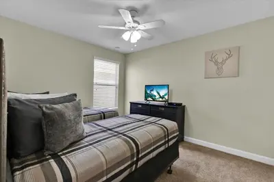 a bedroom with a bed and a ceiling fan at 5-Star Orlando Villa 6452: Family Fun Resort Access in Kissimmee
