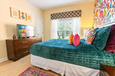 a bedroom with a green bed and a window at Orlando Townhome 6453: Your Private Pool Getaway in Kissimmee