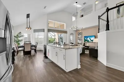 an open kitchen and living room with a dining room and a kitchen and a living at Orlando Villa 6469: 6BR Home Near Disney Parks in Kissimmee