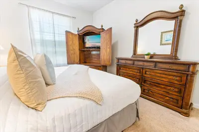 a bedroom with a bed with a dresser and a mirror at Orlando Condo 6470 - 3BR Family Getaway in Kissimmee