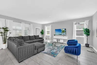 a living room with a couch and a blue chair at You and Your Family will Love this Luxury Villa on Storey Lake Resort Orlando Villa 6295 in Kissimmee