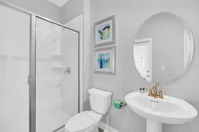 a white bathroom with a toilet and a sink at You and Your Family will Love this Luxury Villa on Storey Lake Resort Orlando Villa 6295 in Kissimmee