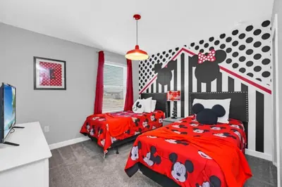 a bedroom with two beds with red comforter at You and Your Family will Love this Luxury Villa on Storey Lake Resort Orlando Villa 6295 in Kissimmee