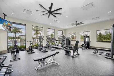 a gym with treadmills and exercise equipment and windows at Orlando Villa 6401 - Dream Stay at Paradiso Resort in Orlando