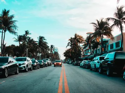 a car is driving down a street with parked cars at Orlando Villa 6394 - Premium Villa at Windsor Hills in Orlando