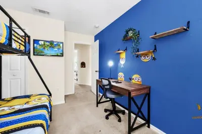 a bedroom with a desk and a blue wall at Orlando Villa 6230: A Stylish Family Retreat Near Disney in Kissimmee