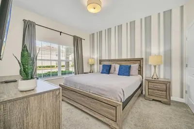 a bedroom with a bed and a large window at Experience Luxury at Orlando Villa 6231 Storey Lake in Kissimmee