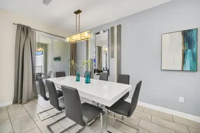 a dining room with a white table and chairs at Experience Luxury at Orlando Villa 6231 Storey Lake in Kissimmee