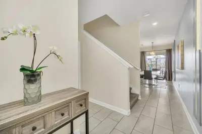 a living room with a vase with flowers on a wooden table at Experience Luxury at Orlando Villa 6231 Storey Lake in Kissimmee