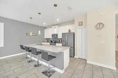 a kitchen with a counter and a refrigerator at Rent Orlando Villa 6235: Perfect Luxury Villa by Disney in Kissimmee