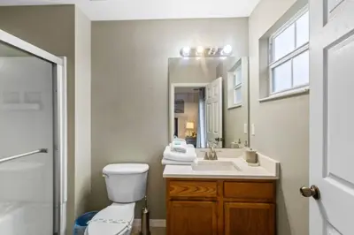 a bathroom with a toilet and a sink and a mirror at Orlando Villa 6244: Luxury 5-Star Villa Minutes from Disney in Kissimmee