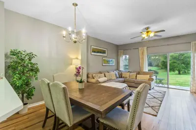 a dining room and living room with a wooden table and chairs at Orlando Villa 6244: Luxury 5-Star Villa Minutes from Disney in Kissimmee