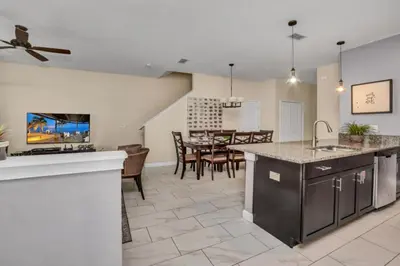 an open kitchen and living room with a dining room at Orlando Villa 6243: The Best Orlando Getaway at Storey Lake in Kissimmee