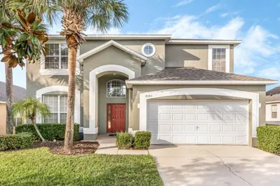 a house with a palm tree and a garage at Orlando Villa 6245: Dream Holiday Villa in Emerald Island in Kissimmee