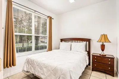 a bedroom with a bed and a window at Orlando Villa 6245: Dream Holiday Villa in Emerald Island in Kissimmee