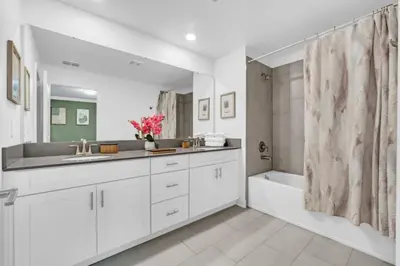 a white bathroom with a sink and a bath tub at Luxury Villa at Storey Lake Resort Near Disney – Orlando Villa 6253 in Kissimmee