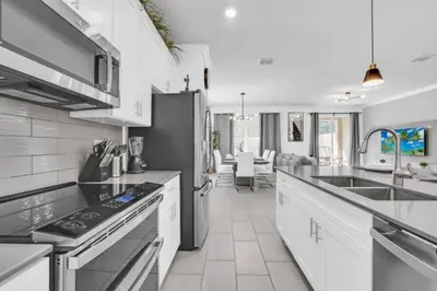a kitchen with white cabinets and a stove top oven at Luxury Villa at Storey Lake Resort Near Disney – Orlando Villa 6253 in Kissimmee