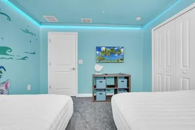 two beds in a room with blue walls at Luxury Villa at Storey Lake Resort Near Disney – Orlando Villa 6253 in Kissimmee
