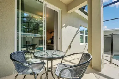 a patio with chairs and a table on a balcony at Luxury Villa at Storey Lake Resort Near Disney – Orlando Villa 6253 in Kissimmee