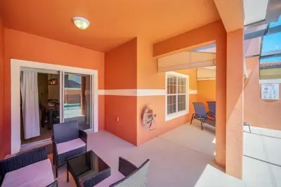 a living room with orange walls and chairs at Orlando Villa 6256: Experience 5-Star Luxury at Paradise Palms Resort in Kissimmee