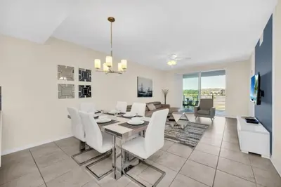 a dining room and living room with a table and chairs at Orlando Condo 6259: Ultimate Family Retreat on Storey Lake in Kissimmee