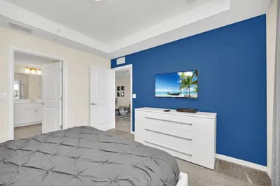 a bedroom with a blue accent wall and a bed at Orlando Condo 6259: Ultimate Family Retreat on Storey Lake in Kissimmee