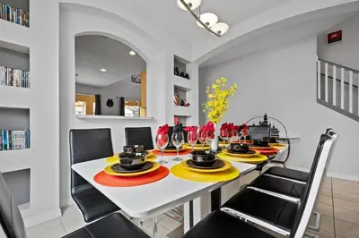 a dining room with a white table and black chairs at Luxury Villa with private Pool Emerald Island Resort Orlando Villa 5074 in Kissimmee