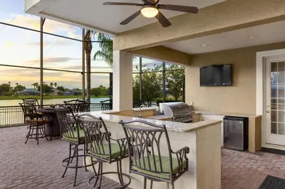 a patio with chairs and a bar with a view at 5 Star Mansion with Private Pool on Formosa Gardens Orlando Manion 5075 in Orlando